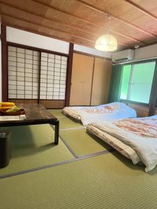 una camera con due letti e un tavolo di WAY SHIRAKAWAGO - Private, Free Parking and Newly Opened 2022 WAY SHIRAKAWAGO a Shirakawa