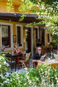 a group of people sitting at tables outside a restaurant at Vagia Traditional, Aegina Island in Vaia