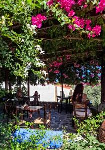 a patio with flowers and people sitting at tables at Vagia Traditional, Aegina Island in Vaia