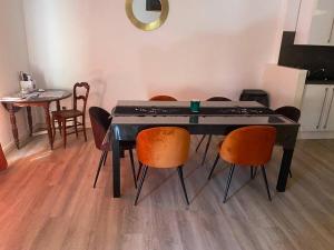 una mesa negra con sillas naranjas en una habitación en Spacieux en plein centre, en Sète