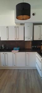 Una cocina con gabinetes blancos y una encimera negra. en Spacieux en plein centre, en Sète