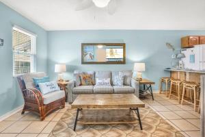 a living room with a couch and a table at Sunrise Village 215- 2BR 1BA gulf front sleep 6 in Gulf Shores