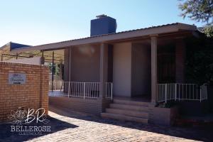 a building with a porch and stairs on it at Bellerose Guesthouse in Klerksdorp