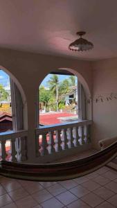 a room with a balcony with a view of a yard at FourStoners Boutique BNB in Belize City