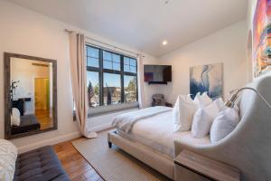 パークシティにあるLespri by Park City Vacationsのベッドと大きな窓のある寝室