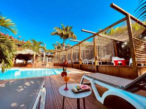 a resort deck with a table with a drink on it at Kawan Bay Suites in Deshaies