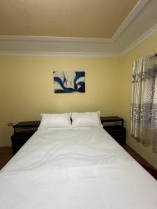 a bedroom with a large bed with white sheets at Xhani Camping&Farm in Gucia e Re