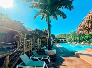 a resort with a swimming pool with chairs and palm trees at Kawan Bay Suites in Deshaies