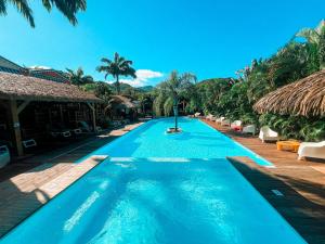 a swimming pool at a resort with palm trees at Kawan Bay Suites in Deshaies