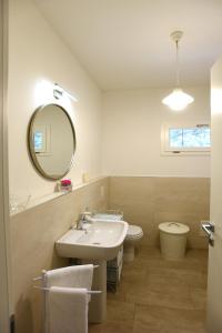 a bathroom with a sink and a toilet and a mirror at Il Granaio letterario in Padova