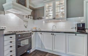 a kitchen with white cabinets and a stove top oven at 3 Bedroom Cozy Home In Voorthuizen in Voorthuizen
