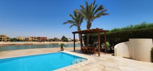 a swimming pool with a gazebo and a palm tree at Nayah Stays, Lagoons beach, Paradise 3 ensuite with private pool in El Gouna