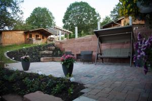 un patio con sedie e fiori in un cortile di Ferienhof-Gerda-Ferienwohnung-Sternenhimmel a Oberkirnach Altre 13 foto