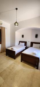 a bedroom with two beds and a light at Nayah Stays, Lagoons beach, Paradise 3 ensuite with private pool in El Gouna +40 photos