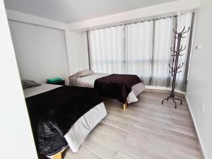 a bedroom with two beds and a window at Sr de Huanca in Mollepata