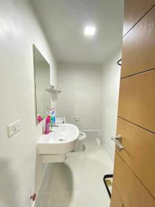 a white bathroom with a sink and a mirror at Studio Condo near Ayala, Cebu-East Gate in Carreta