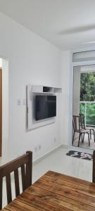 a dining room with a table and a television on a wall at Apartamento lumier 109 in Ubatuba +5 photos