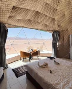 1 dormitorio con cama y vistas al desierto en Wadi Rum Camp tr, en Wadi Rum