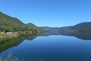 Una vista de un lago con montañas al fondo. en Casa de Freixo, en Freixo de Espada à Cinta