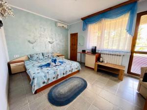 a bedroom with a bed with a blue comforter at Kastela Guest House in Chernomorets