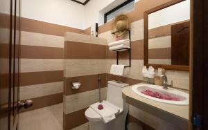 ein Badezimmer mit Waschbecken, Toilette und Spiegel in der Unterkunft The Urban in Siem Reap