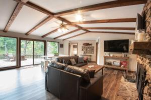 Heber SpringsRiverfront Retreat with Fire Pit Fish and Hike!的客厅设有真皮沙发和壁炉