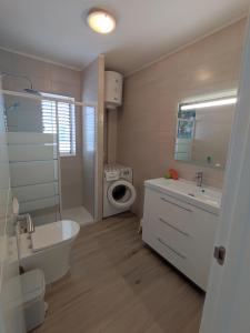 a bathroom with a sink and a toilet and a mirror at 16 Sunset view in Adeje