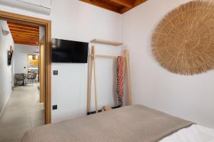 a bedroom with a bed and a flat screen tv on the wall at Tapanis luxury house in Líndos