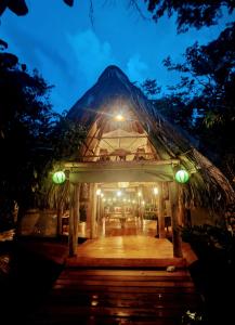 a lit up building with a pyramid roof at night at La Isla Dulce in Lívingston