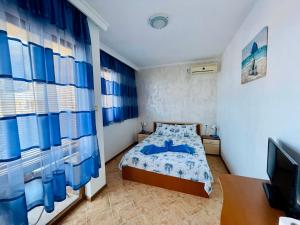 a small bedroom with a bed and a television at Kastela Guest House in Chernomorets