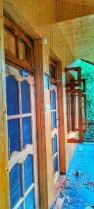 an inside view of a cabin with two windows at Hercue's Hillside Homestay in Shirir