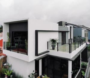a white house with black windows and a balcony at Villa inspired with exclusive dipping pool in Bacolod