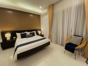 a bedroom with a large bed and a chair at Villa inspired with exclusive dipping pool in Bacolod