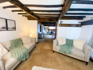 a living room with two white couches and a couch at Stunning character cottage near Keswick in Threlkeld