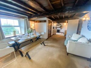 a living room with a table and a couch at Stunning character cottage near Keswick in Threlkeld