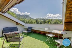 a balcony with chairs and a table and a large window at LEscapade du Col Cozy 2-Bedroom Apartment in Bluffy