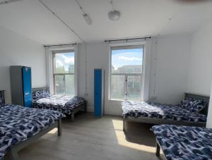 um quarto com três camas e duas janelas em Dublin Quayside Hostel em Dublin