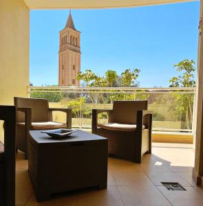 una stanza con due sedie e un tavolo e una torre dell'orologio di Monita 113, Seaside Apartment with Access to Pool and Pleasant Views a Marsaskala