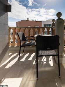 a pair of chairs sitting on top of a balcony at Arinaga Beach - Sea View & Terrace Apartment in Arinaga
