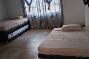 a bedroom with two beds and a tiled floor at La Posada De Shaz En Norcasia in Norcasia