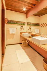 a bathroom with two sinks and two mirrors at Hotel Ponta do Madeiro in Pipa