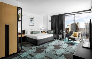 a bedroom with a bed and a couch and a chair at Downtown Grand Hotel & Casino in Las Vegas