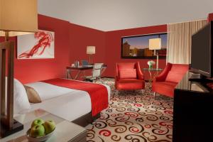 a hotel room with a bed and red walls at Downtown Grand Hotel & Casino in Las Vegas