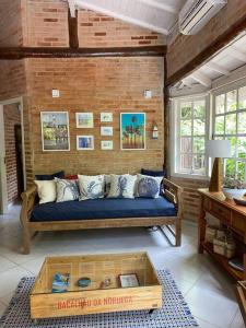 a living room with a couch and a coffee table at Casa charmosa em Juquehy cercada de verde, 2 quartos com churrasqueira in São Sebastião