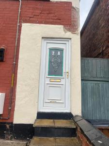 Una puerta blanca con un cartel al lado de un edificio en 2 bedroom flats Apartments Thorney wood, en Nottingham