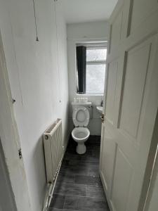 Un pequeño baño con inodoro y ventana. en 2 bedroom flats Apartments Thorney wood, en Nottingham