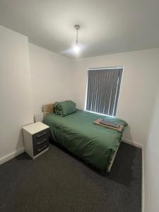 Un dormitorio con una cama verde y una ventana. en 2 bedroom flats Apartments Thorney wood, en Nottingham 6 fotos más