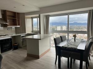 a kitchen with a table with chairs and a large window at Moderno Departamento Piso 16 con pileta in Mendoza