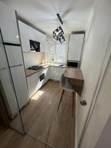 a small kitchen with white cabinets and a table at MK Apartments in Piatra Neamţ