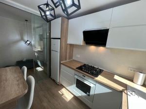 a kitchen with white cabinets and a stove top oven at MK Apartments in Piatra Neamţ